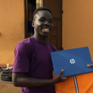 Murye Godfrey receiving a laptop from Bishop-Joseph