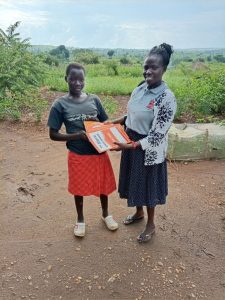 Kiden Christine Amule receiving her study materials