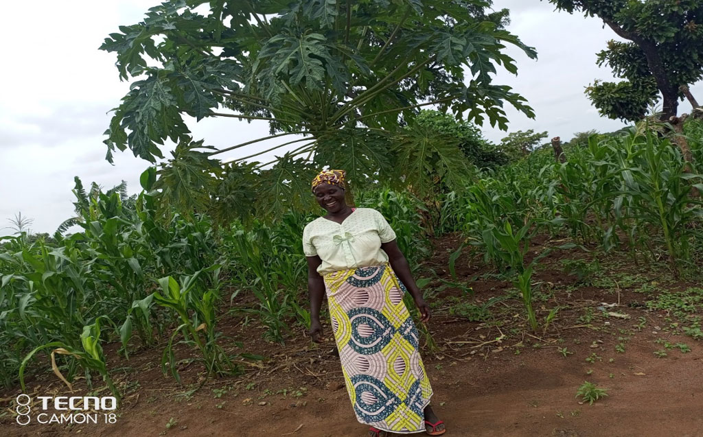 Photograph of Samuel Doa's wife with her Papaya plant