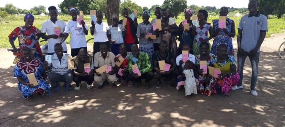 savings group smiling in shade under a tree
