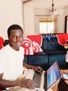 Loku Charles Eluzai with Laptop