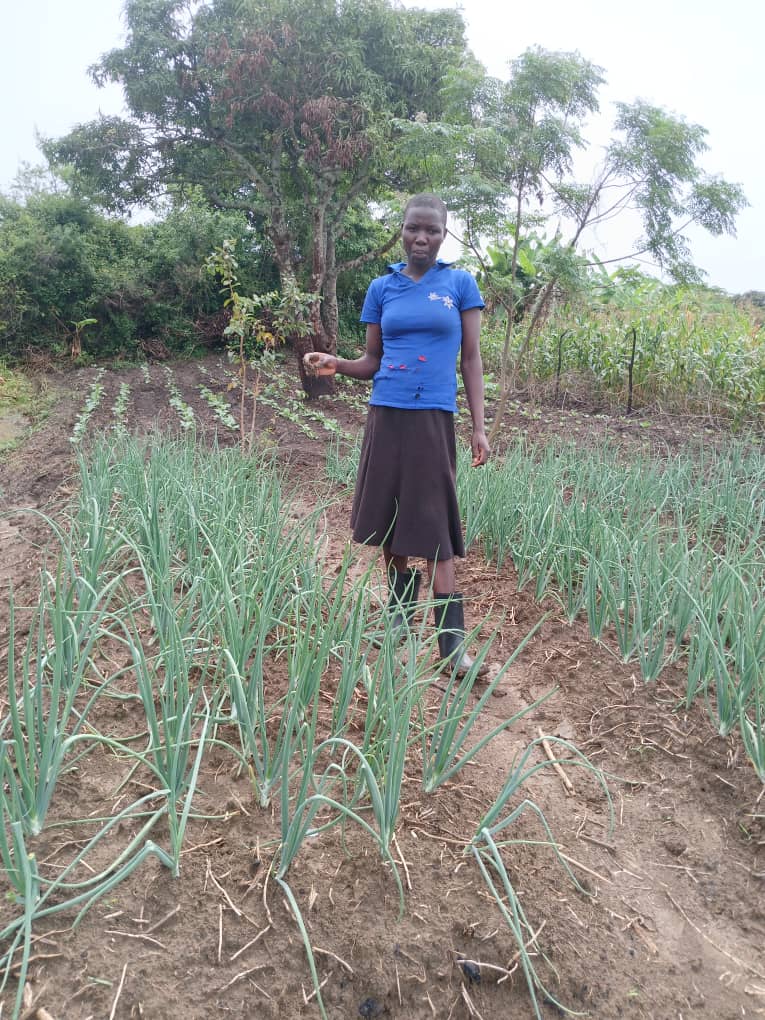 woman wearing blue top and black skirt standing in a young crop.