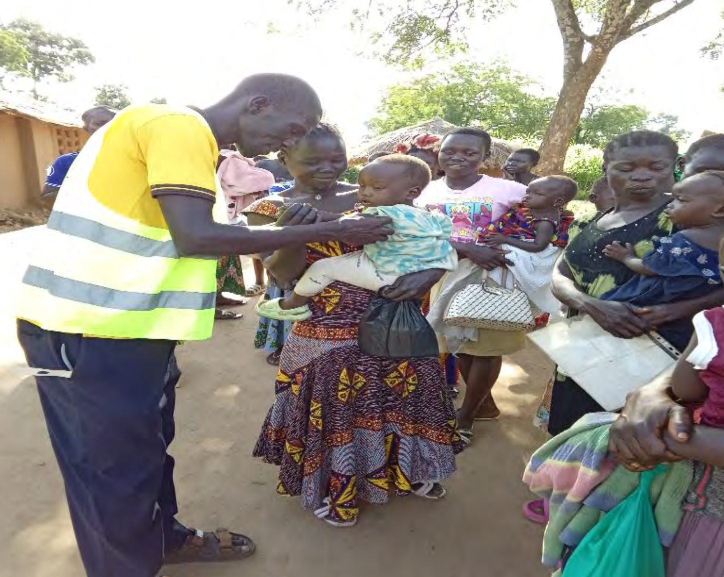 man in yellow high-vis jacket tending to mother and baby.