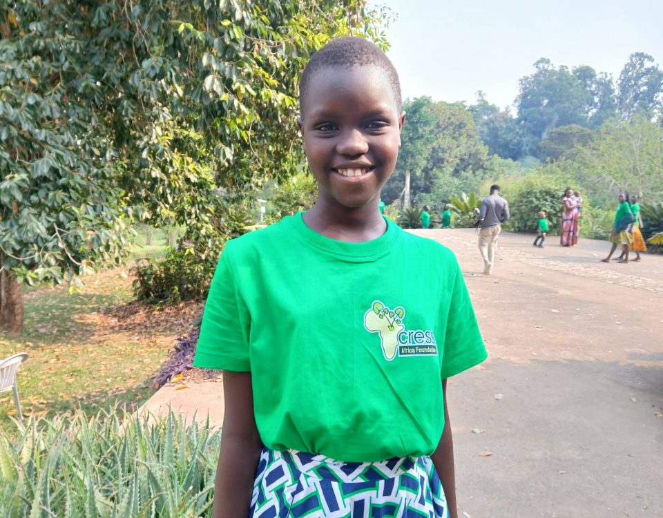 Girl in bright green tshirt, with yellow Africa logo and green patterned skirt.
