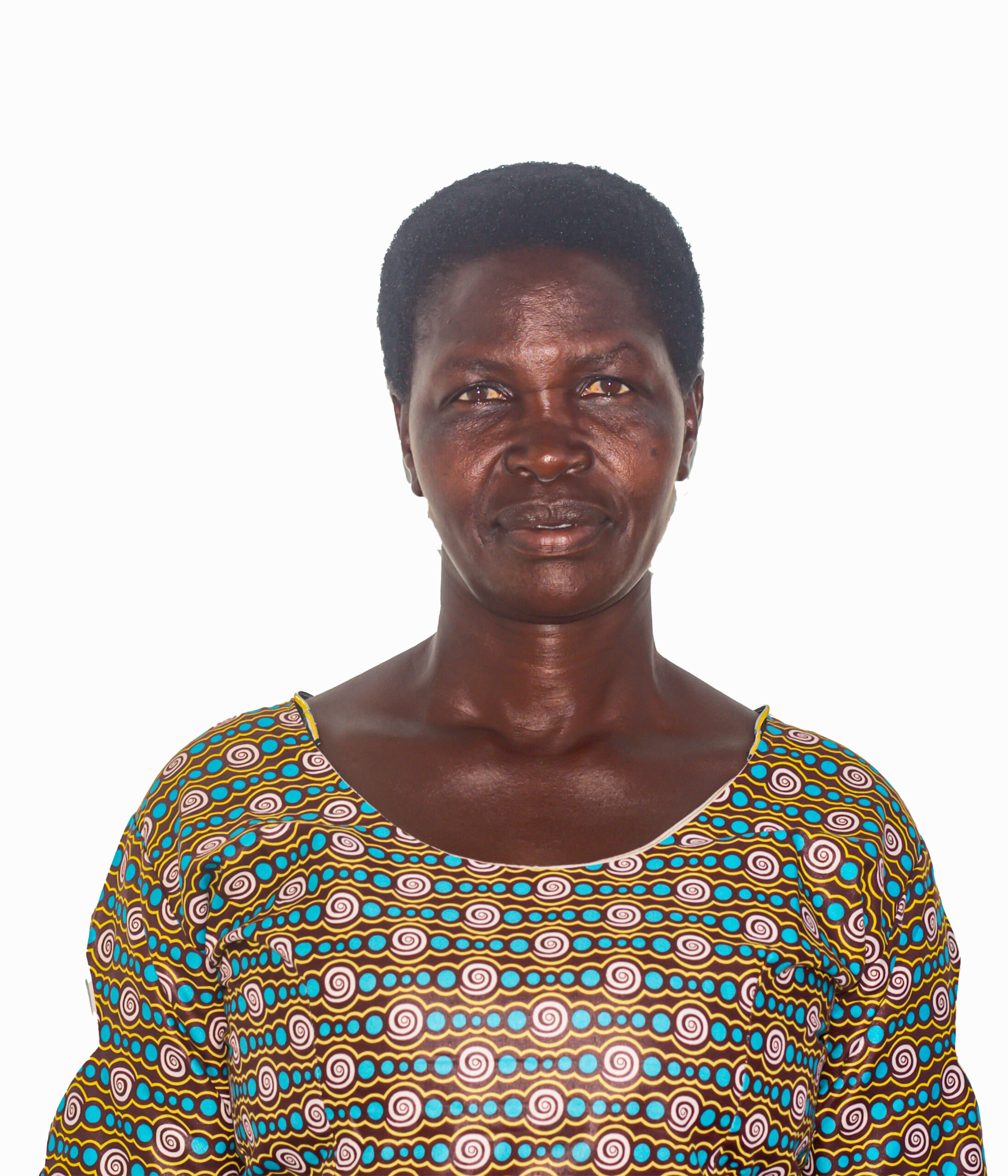 woman in front of white background. she has a small smile on her face. she is wearing an orange and green patterned dress