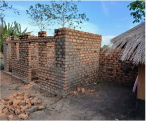 brick building construction. structure has doors and windows on front of building, no roof