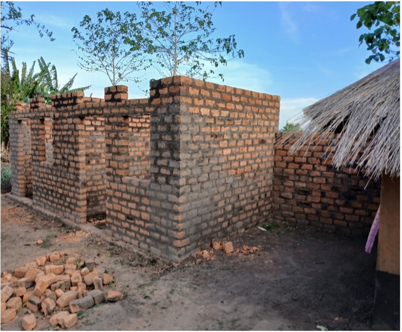 brick building construction. structure has doors and windows on front of building, no roof