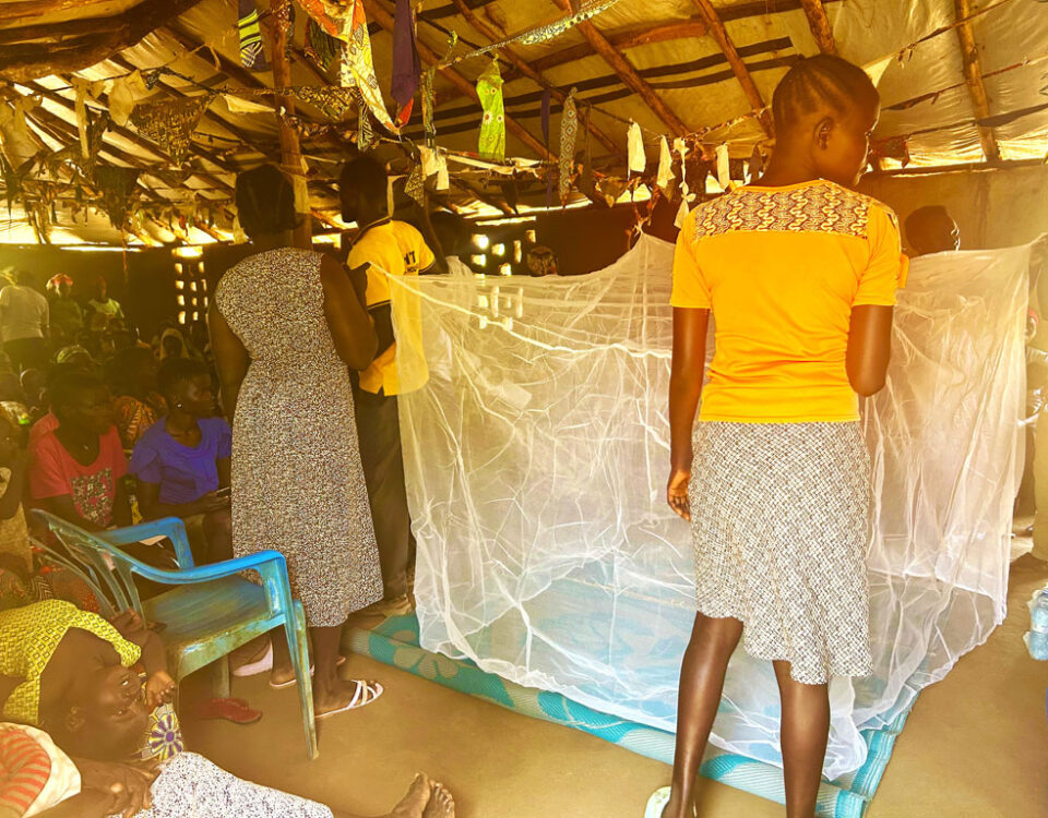 Mothers demonstrating how to hang a mosquito net